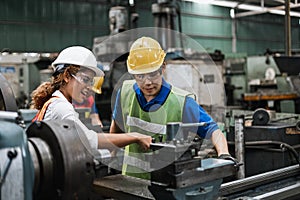 Man and woman engineer industry worker wearing hard hat in factory.