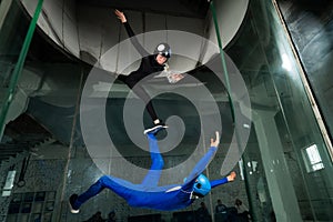 A man and a woman enjoy flying together in a wind tunnel. Free fall simulator