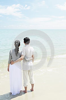 Man and woman enjoying the beautiful view on the beach. Conceptual image