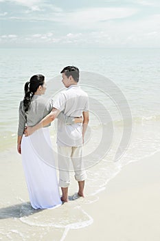 Man and woman enjoying the beautiful view on the beach. Conceptual image