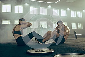 Man and woman during exercises in the fitness gym. CrossFit.