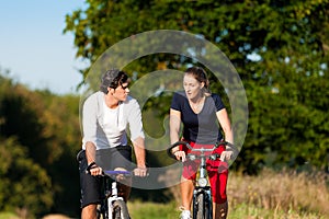 Man and woman exercising with bicycle