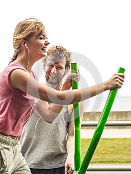 Man and woman exercising on elliptical trainer.