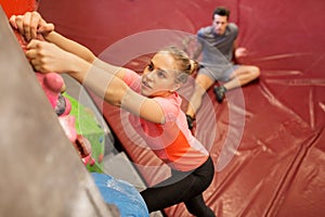 Man and woman exercising at indoor climbing gym
