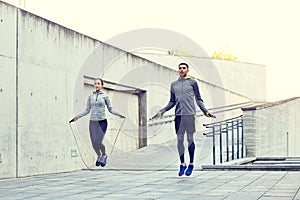 Man and woman exercising with jump-rope outdoors