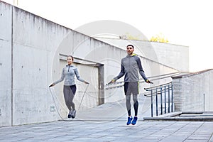 Man and woman exercising with jump-rope outdoors