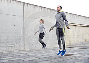 Man and woman exercising with jump-rope outdoors