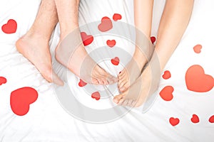 Man and woman feet on the bed with hearts