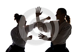 Man and woman fighting at Aikido training in martial arts school