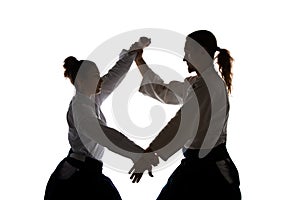 Man and woman fighting at Aikido training in martial arts school