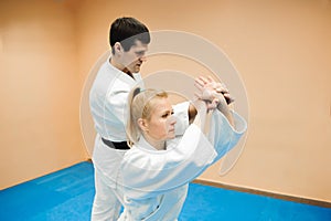 Man and woman fighting at Aikido training in martial arts school.