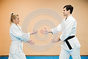 Man and woman fighting at Aikido training in martial arts school