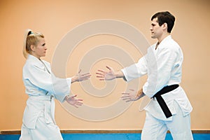 Man and woman fighting at Aikido training in martial arts school.