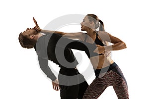 Man and woman fighting in studio, women`s self-defense concept