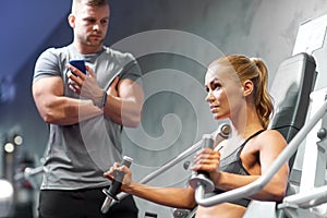 Man and woman flexing muscles on gym machine