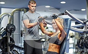 Man and woman flexing muscles on gym machine