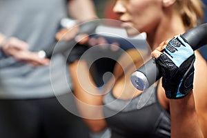 Man and woman flexing muscles on gym machine