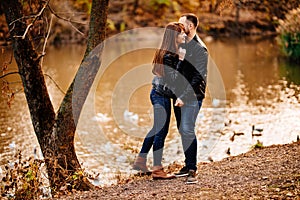 Man and woman flirt in autumn park near river