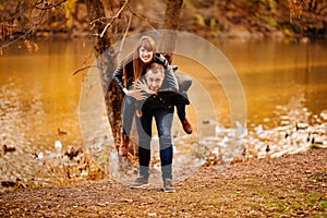 Man and woman flirt in autumn park near river