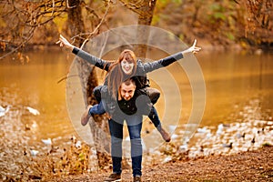 Man and woman flirt in autumn park near river