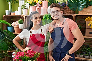 Man and woman florists smiling confident standing at flower shop