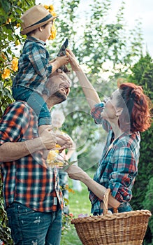 a man and a woman are fooling around together, a child is sitting on the manâ€™s shoulders