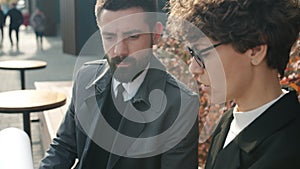 Man and woman in formal clothing talking discussing business in open air cafe