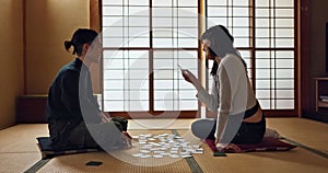 Man, woman and game with Japanese cards on floor in challenge, contest or problem solving with clue. People, couple and