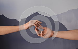 Man and woman giving each other hands on grey background. Concept of support and help