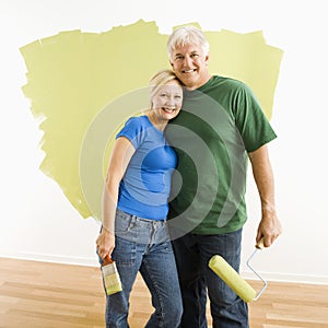 Man and woman with half-painted wall.