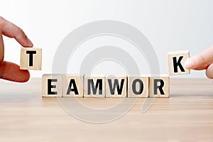 Man and woman hand building teamwork word on wooden cubes, success in business concept background