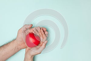 Man and woman hands holding red heart, health care, donate and family insurance concept, world heart day.