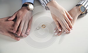 Man and woman hands with ring on desk