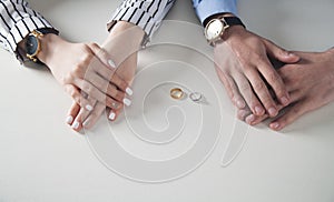 Man and woman hands with ring on desk