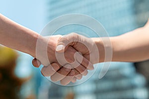 Man and woman handshake with business city background