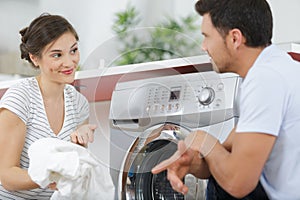 man and woman hanging laundry on clothing rack