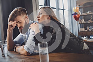 Man and woman with hangover with medicines in messy room