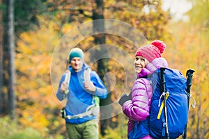 Man and woman happy couple hikers walking in autumn woods