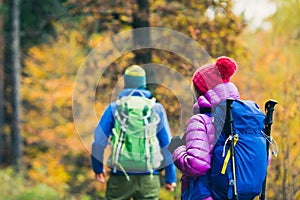 Man and woman happy couple hikers walking in autumn woods