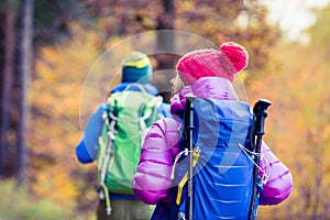 Man and woman happy couple hikers walking in autumn woods