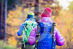 Man and woman happy couple hikers walking in autumn woods