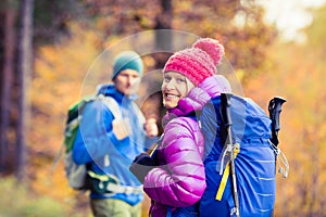 Man and woman happy couple hikers walking in autumn woods