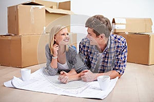 Man, woman and happy with floor plan blueprints for home renovation or moving boxes, apartment or investing. Couple