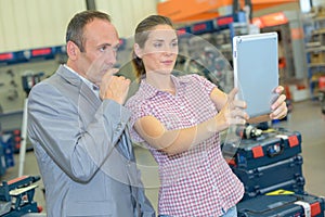 Man and woman in hardware store holding tablet