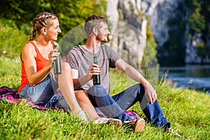 Man and woman having break hiking at river