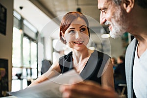 Man and woman having business meeting in a cafe, discussing issues.