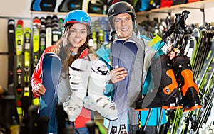 man and woman in helmets choosing sports equipment