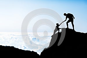 Man and woman help silhouette in mountains