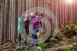 Man and Woman Hikers Staying in Dense Old Forest Smiling and Pointing