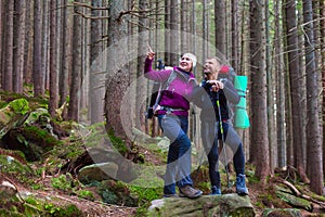 Man and Woman Hikers Staying in Dense Old Forest Smiling and Pointing